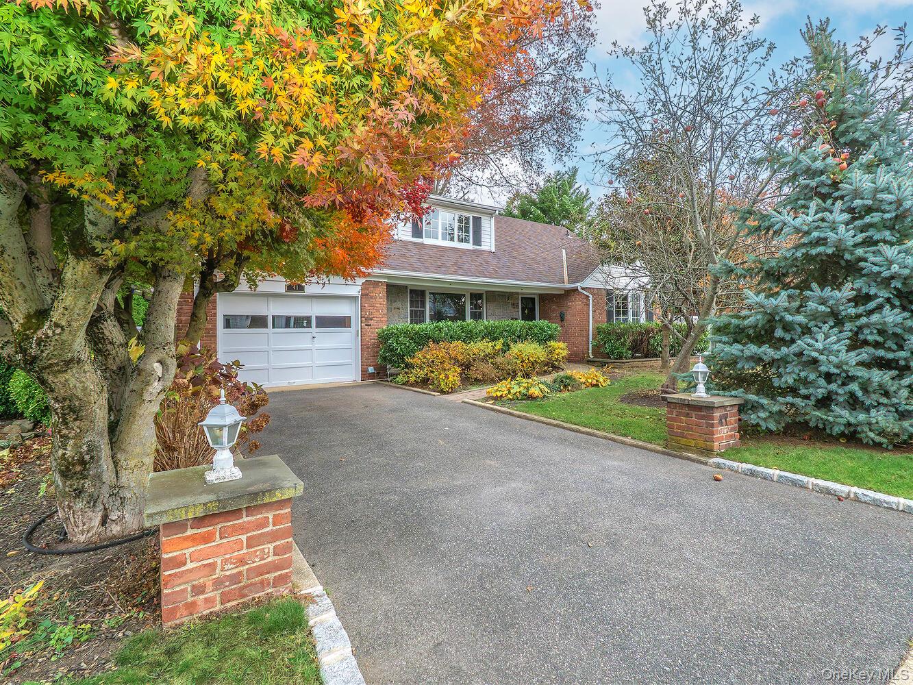 41 South 4th Street Locust Valley, NY 11560 - Photo 34 of 39 View of front of home featuring a shingled roof, brick siding, driveway, and a garage