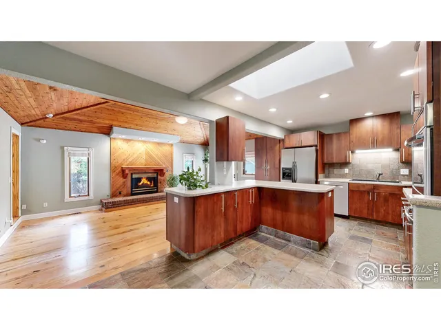 a living room with stainless steel appliances kitchen island granite countertop a sink cabinets and wooden floor