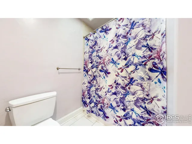 a bathroom with a toilet and a shower curtain