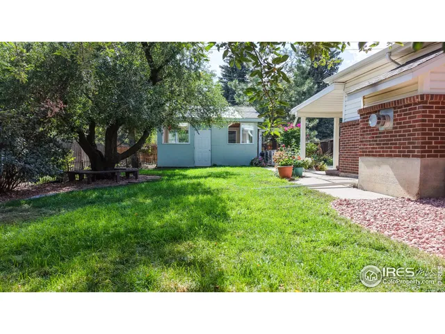 a backyard of a house with table and chairs
