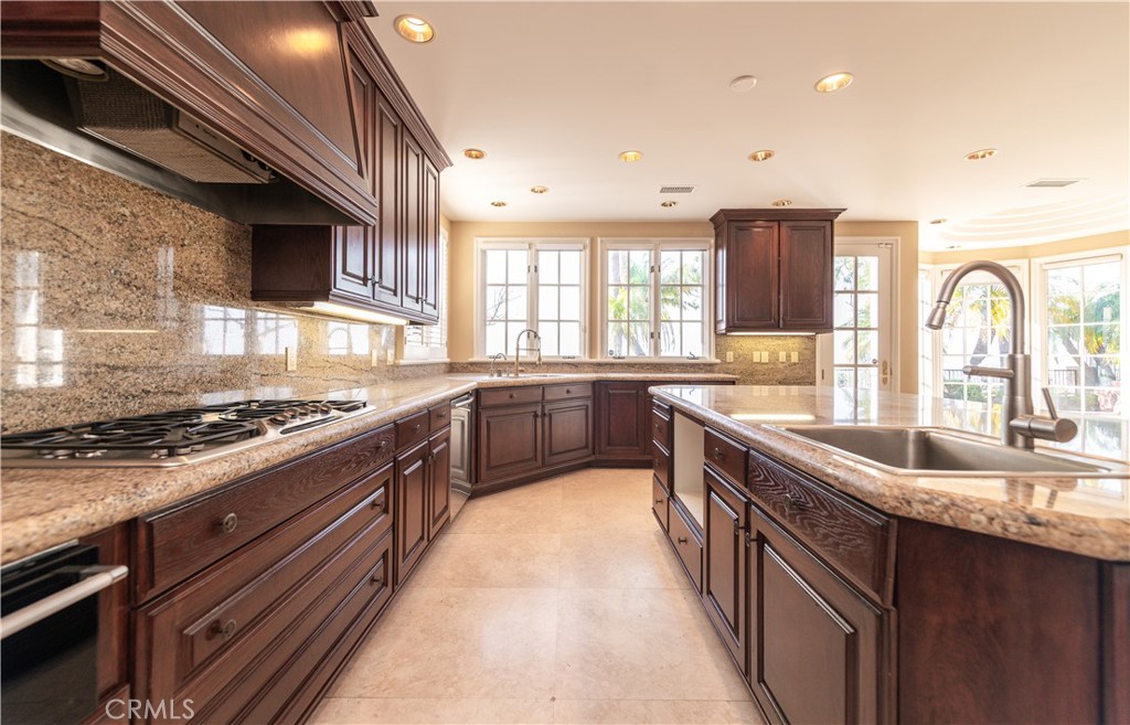 5 Sunpeak Irvine, CA 92603 - Photo 15 of 42 a kitchen with stainless steel appliances granite countertop a sink a stove top oven a counter space and cabinets