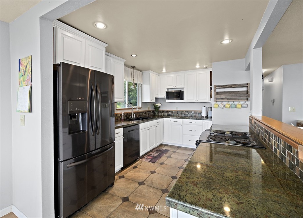 30002 2nd Avenue Southwest Federal Way, WA 98023 - Photo 11 of 34 a kitchen with granite countertop a refrigerator and a sink