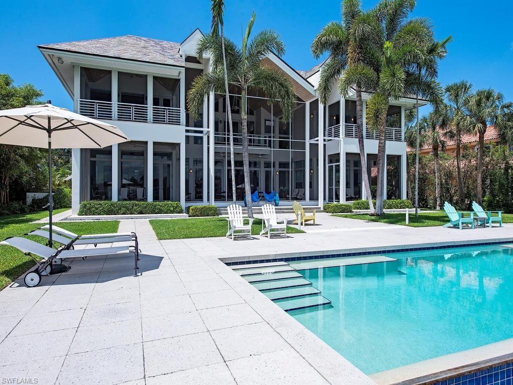 4253 Cutlass Lane Naples, FL 34102 - Photo 11 of 47 a view of a building with a yard and swimming pool