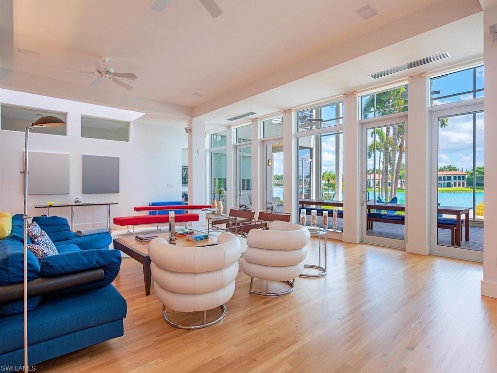 4253 Cutlass Lane Naples, FL 34102 - Photo 23 of 47 a living room with furniture and floor to ceiling windows