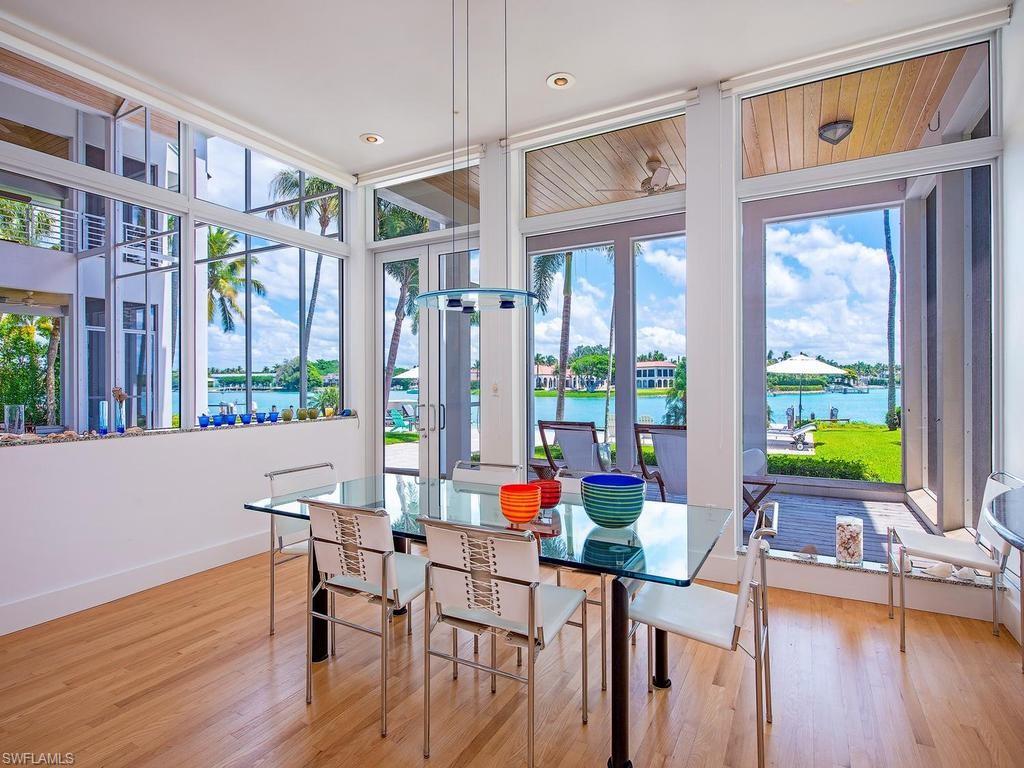 4253 Cutlass Lane Naples, FL 34102 - Photo 30 of 47 a living room with furniture a flat screen tv and floor to ceiling windows
