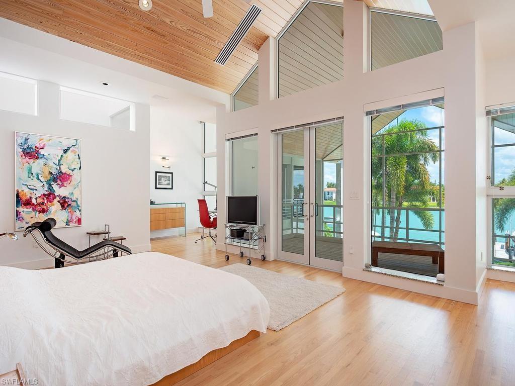 4253 Cutlass Lane Naples, FL 34102 - Photo 32 of 47 a bedroom with a bed and wooden floor