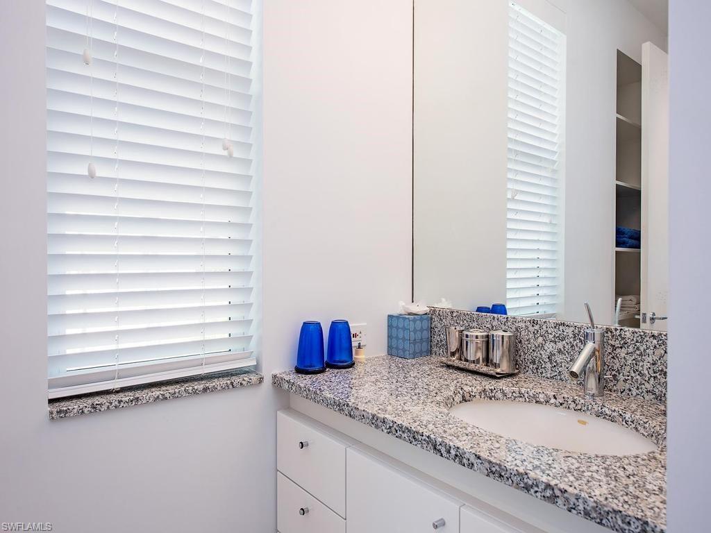 4253 Cutlass Lane Naples, FL 34102 - Photo 38 of 47 a bathroom with a granite countertop sink and a mirror