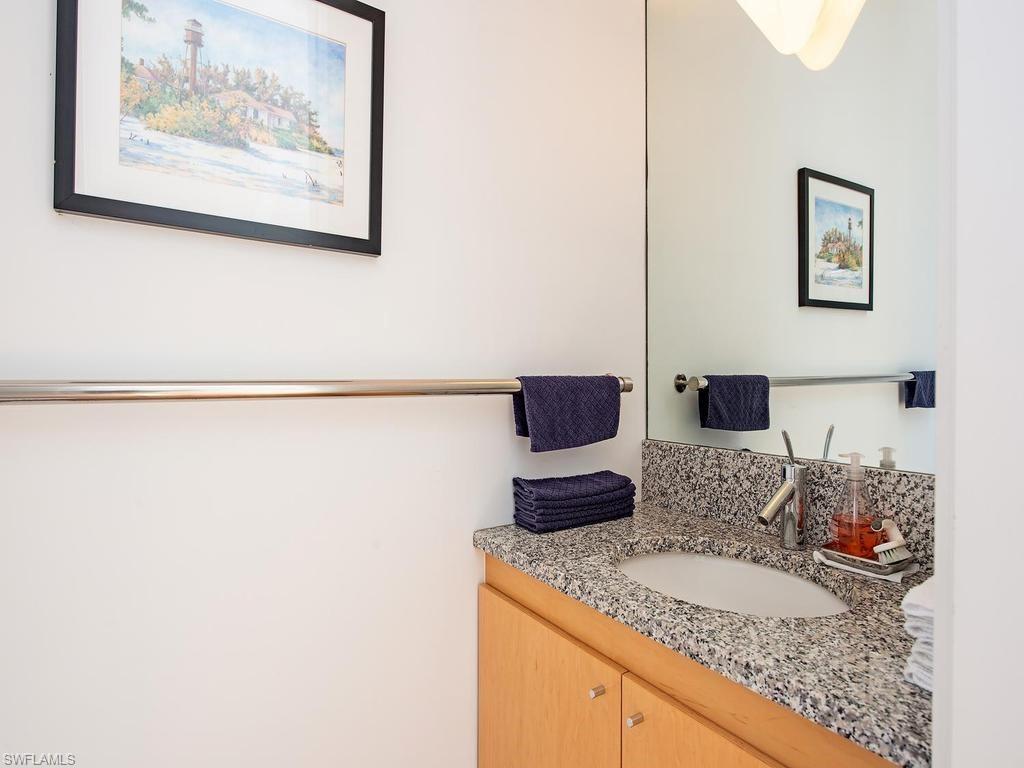 4253 Cutlass Lane Naples, FL 34102 - Photo 40 of 47 a en suite bathroom with a granite countertop sink and a mirror