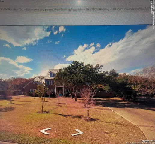 a front view of a house with a yard and trees