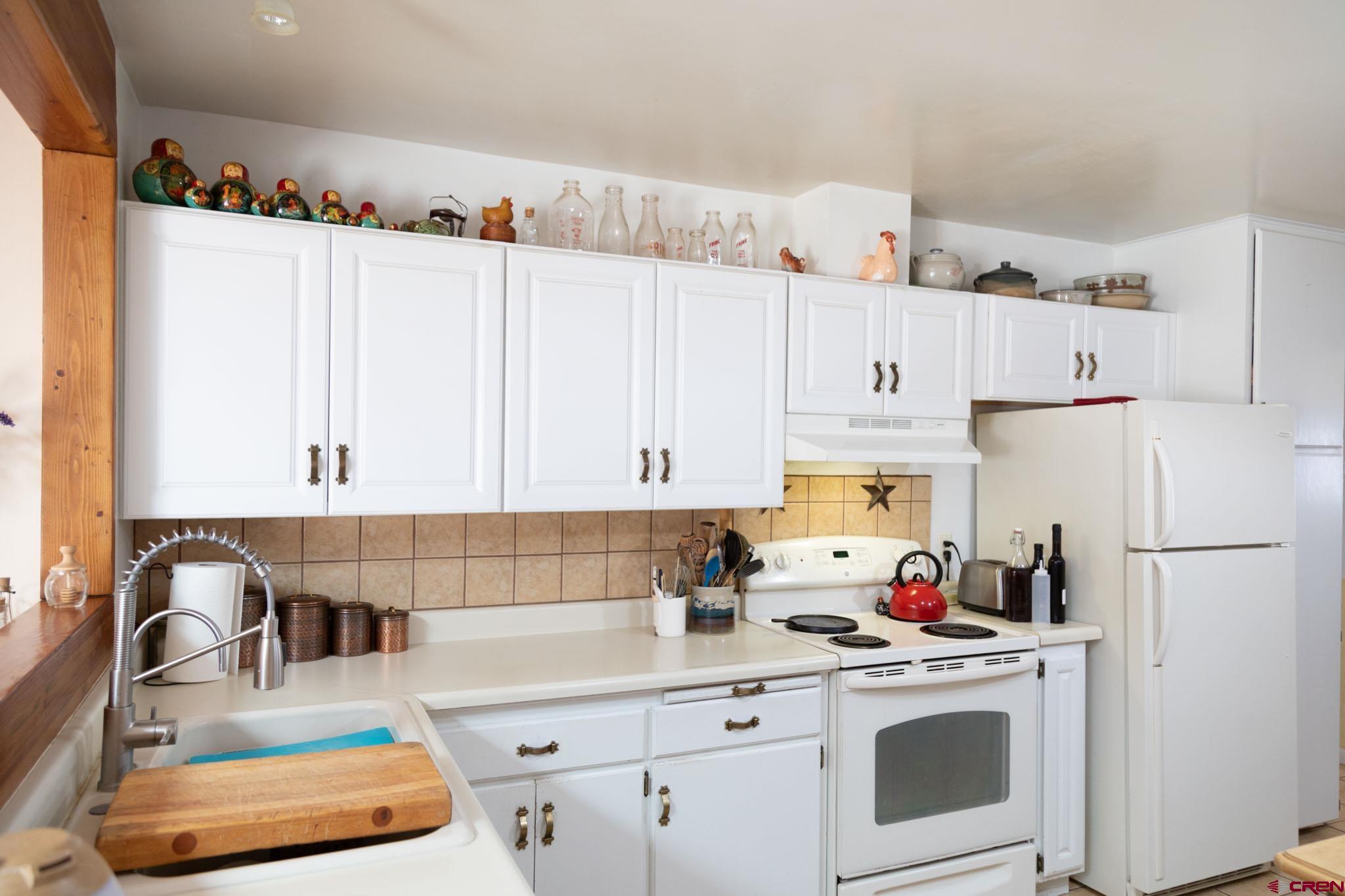 711 First Street Alamosa, CO 81101 - Photo 1 of 21 a kitchen with granite countertop a white refrigerator and cabinets