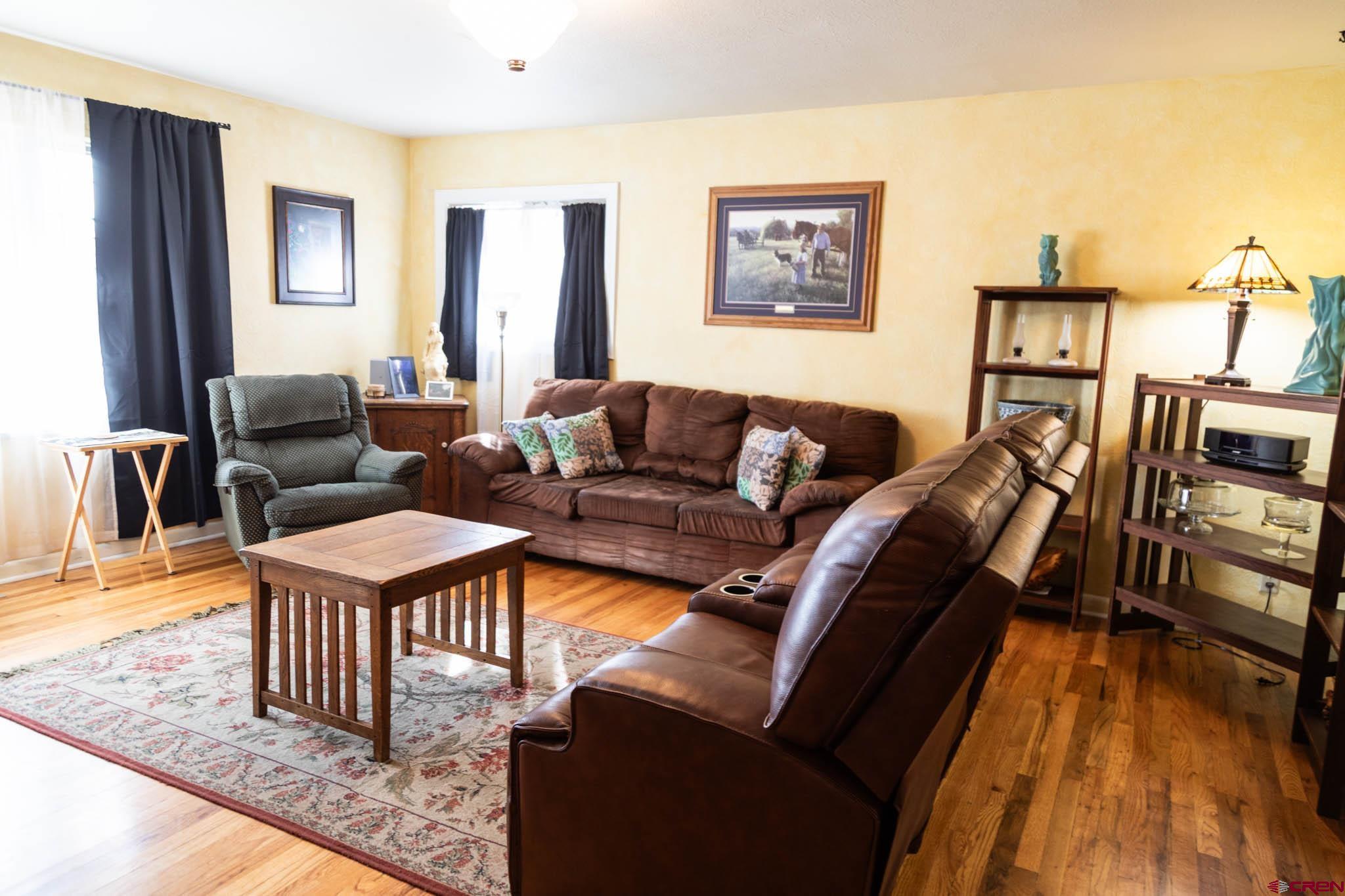711 First Street Alamosa, CO 81101 - Photo 16 of 21 a living room with furniture and a flat screen tv with wooden floor