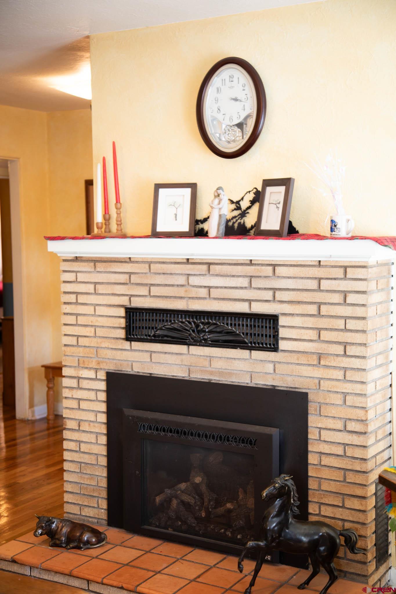 711 First Street Alamosa, CO 81101 - Photo 17 of 21 a fireplace with a clock on the wall