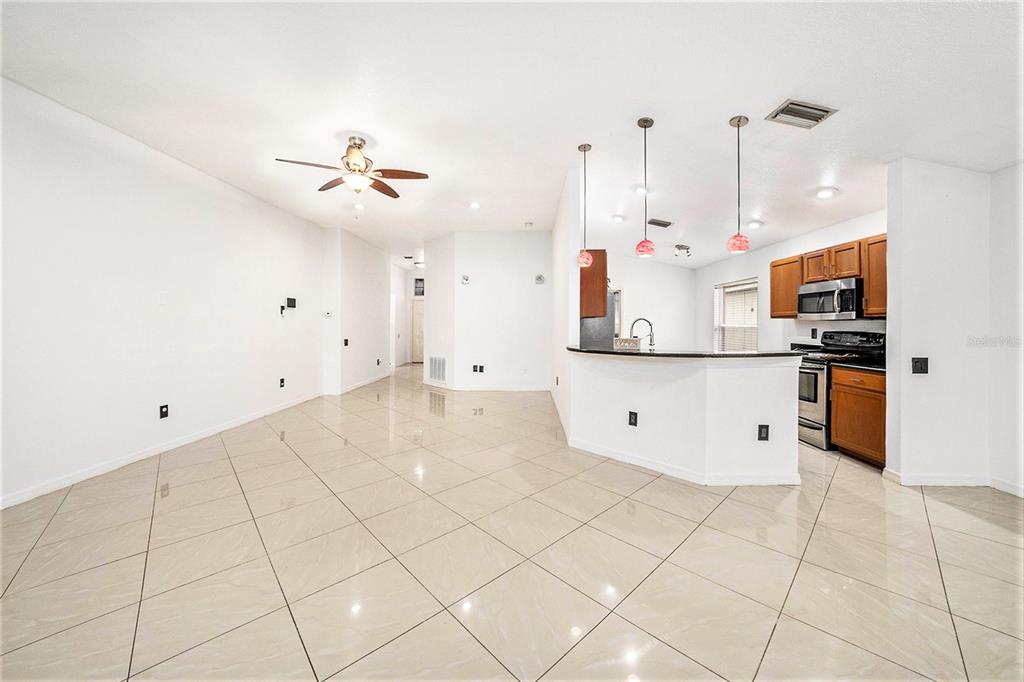 5644 Grindstone Loop Wesley Chapel, FL 33544 - Photo 11 of 29 a kitchen with stainless steel appliances kitchen island granite countertop a stove a sink and a refrigerator