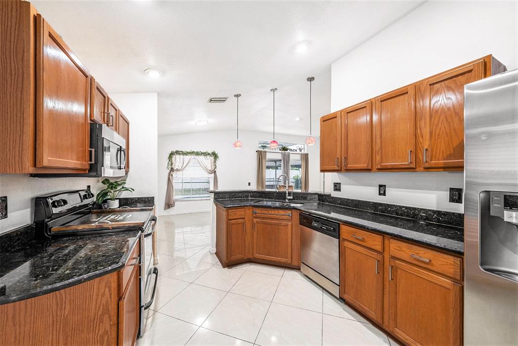 5644 Grindstone Loop Wesley Chapel, FL 33544 - Photo 12 of 29 a kitchen with stainless steel appliances granite countertop a sink stove and cabinets