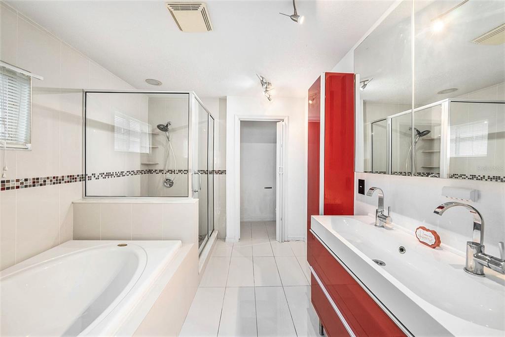 5644 Grindstone Loop Wesley Chapel, FL 33544 - Photo 17 of 29 a bathroom with a tub a sink and a large mirror