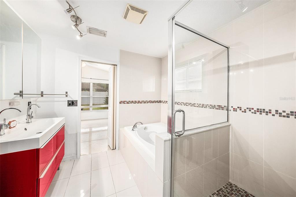 5644 Grindstone Loop Wesley Chapel, FL 33544 - Photo 18 of 29 a spacious bathroom with a double vanity sink a mirror and shower