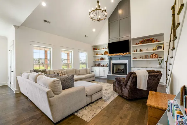 a living room with furniture a flat screen tv and a fireplace