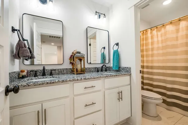 a bedroom with a dresser and a chandelier
