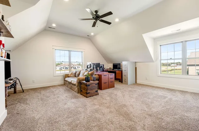 a living room with furniture a flat screen tv and a window
