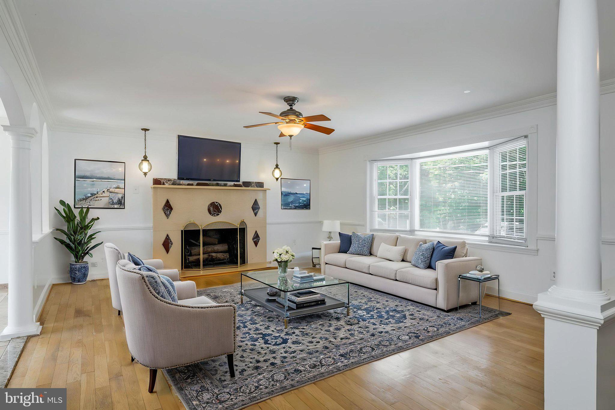 11325 Bacon Race Road Woodbridge, VA 22192 - Photo 7 of 54 a living room with furniture a fireplace a flat screen tv and a large window