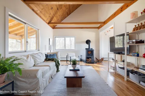a living room with furniture large window and wooden floor