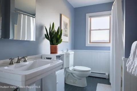 a bathroom with a sink toilet and a mirror