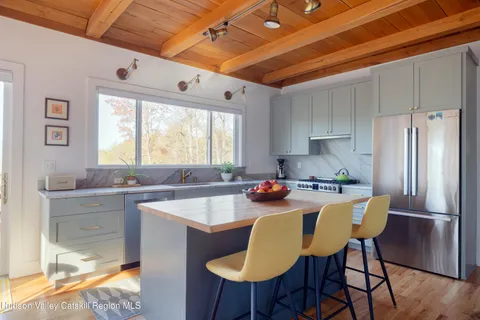 a kitchen with stainless steel appliances a table chairs and a refrigerator