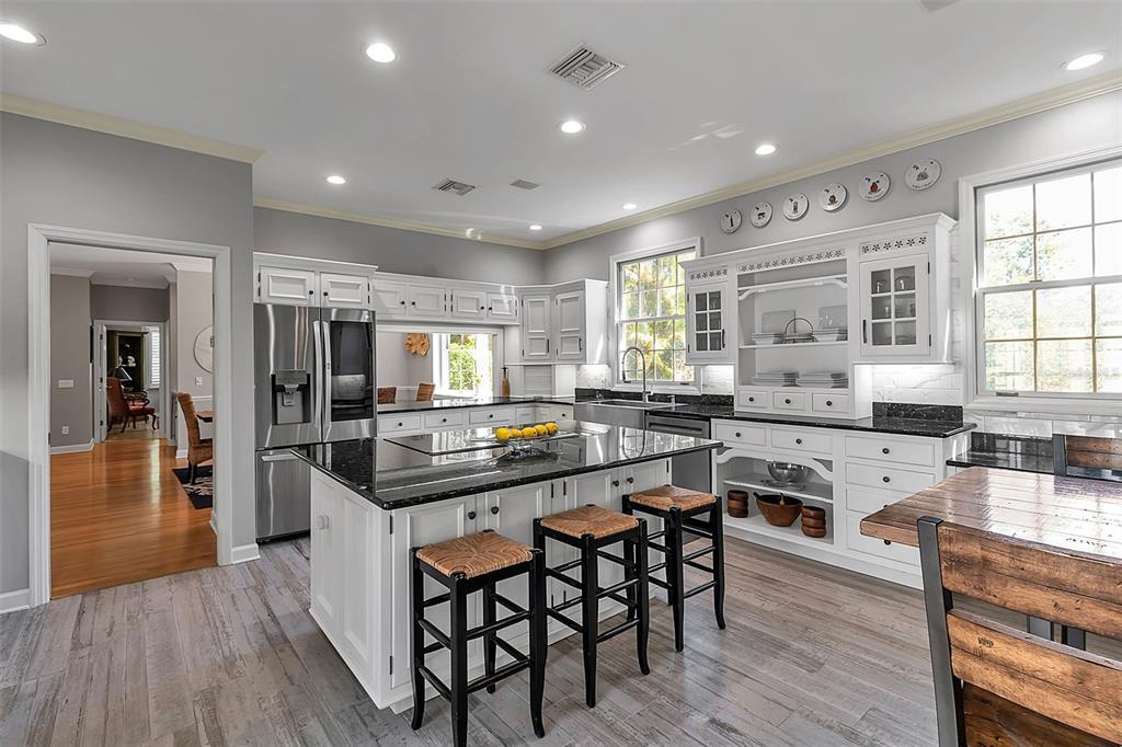156 Bishopscourt Road Osprey, FL 34229 - Photo 40 of 84 a kitchen with stainless steel appliances granite countertop wooden floor window and cabinets