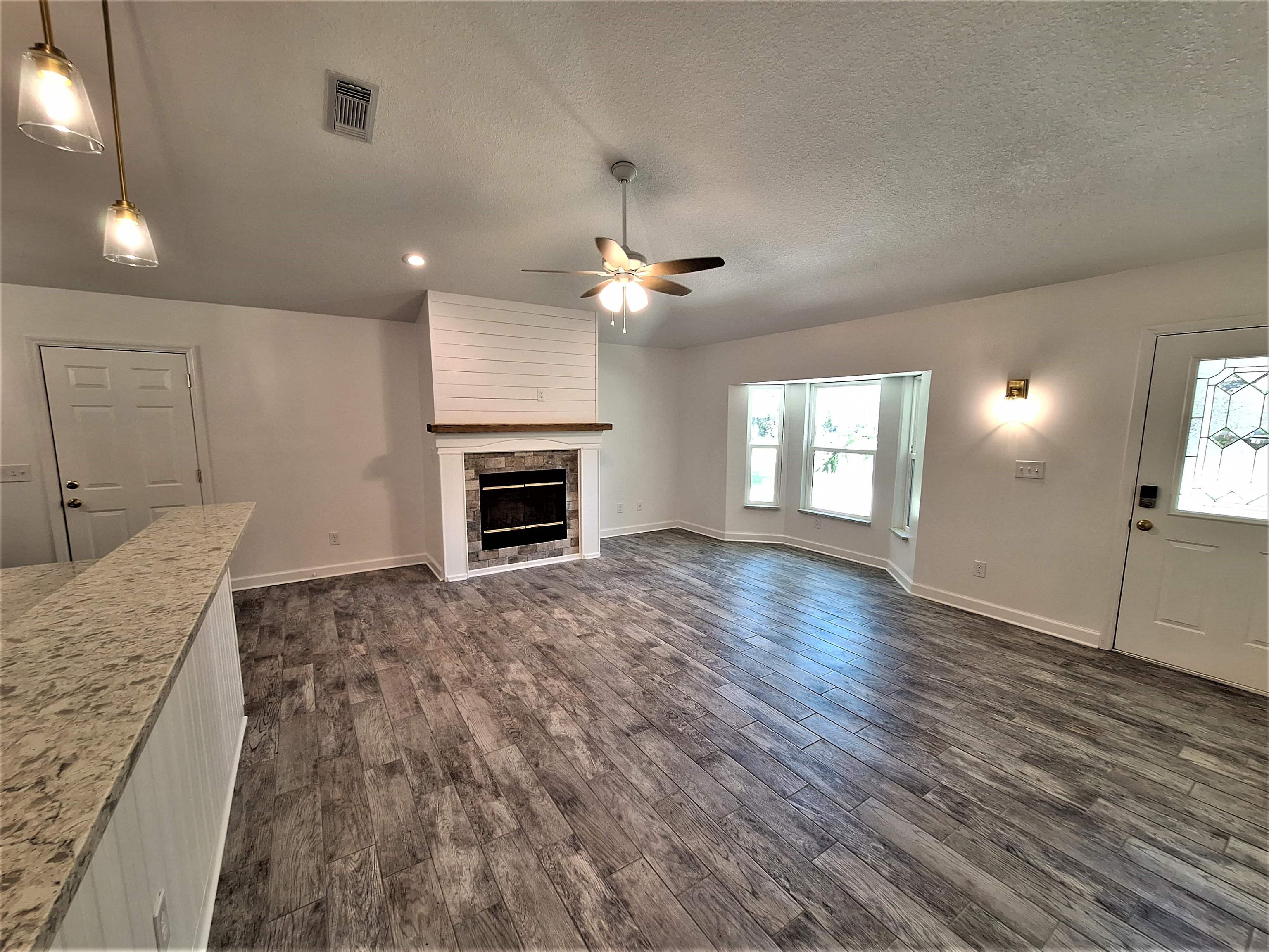 129 15th Street St. Augustine, FL 32080 - Photo 16 of 61 an empty room with wooden floor fireplace and windows