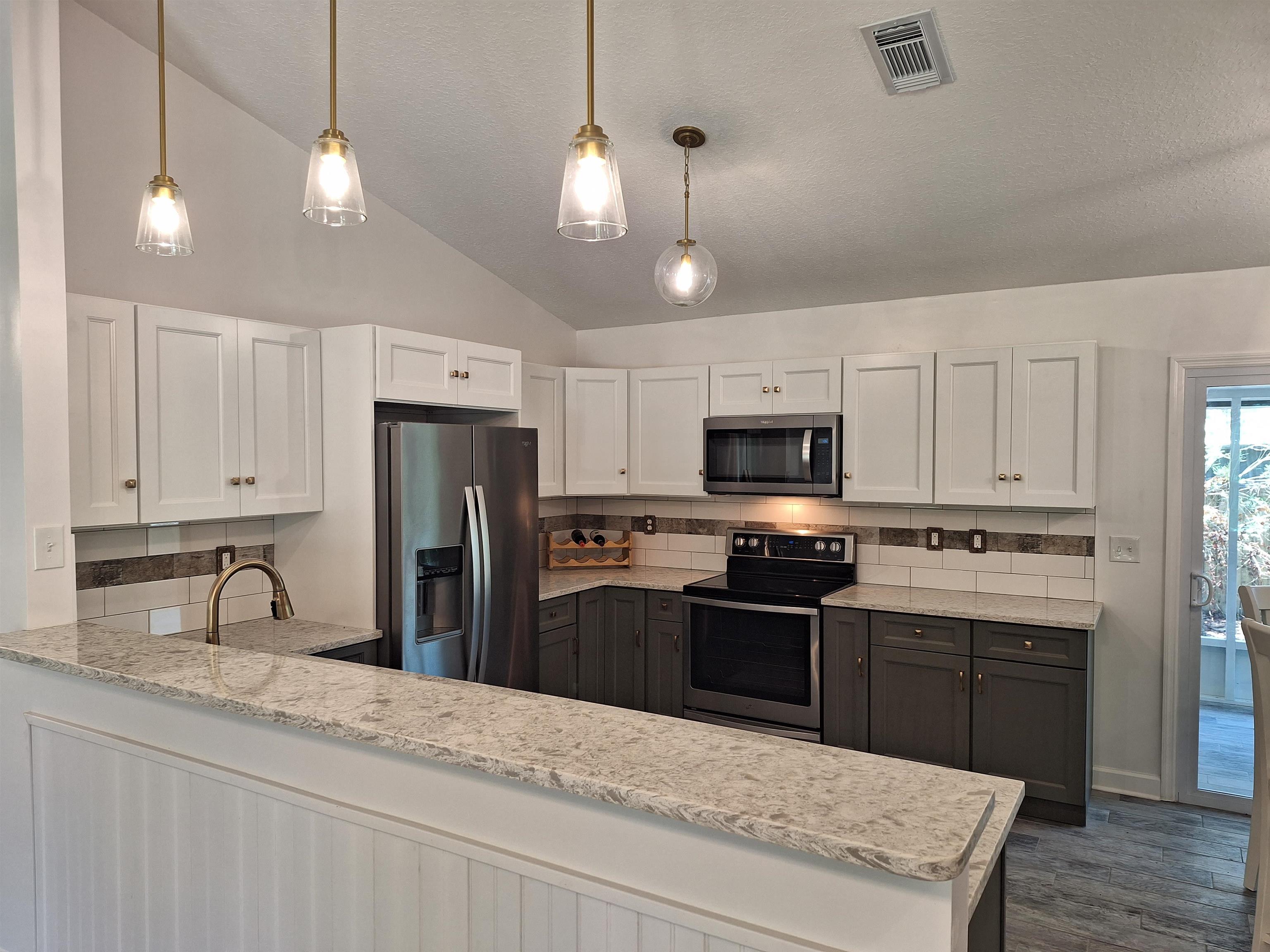 129 15th Street St. Augustine, FL 32080 - Photo 17 of 61 a kitchen with stainless steel appliances granite countertop a sink refrigerator and stove