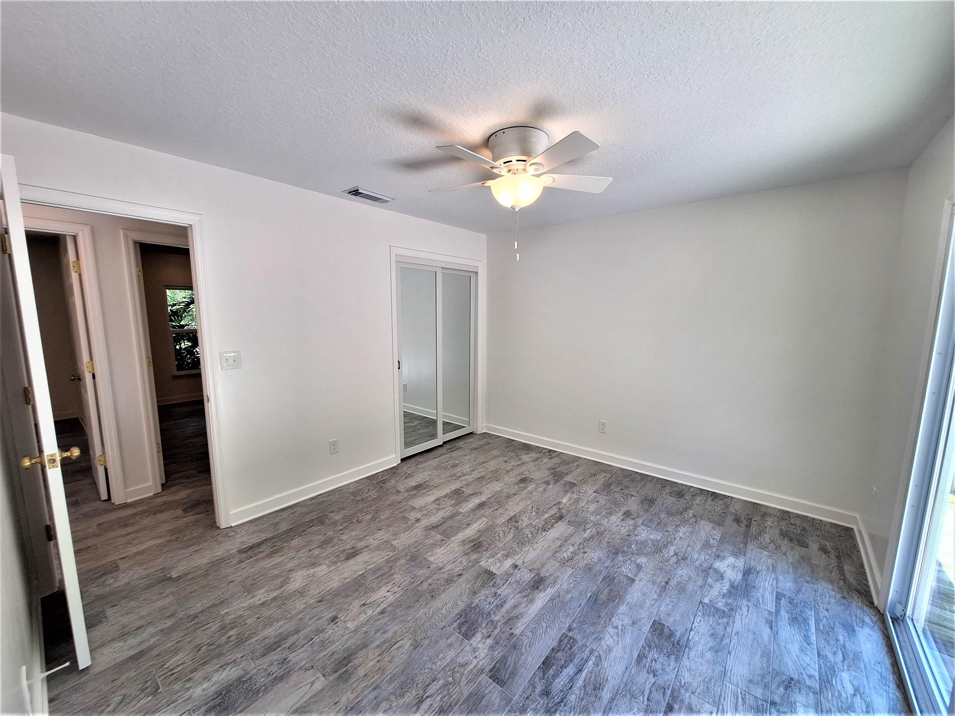 129 15th Street St. Augustine, FL 32080 - Photo 27 of 61 an empty room with wooden floor and ceiling fan