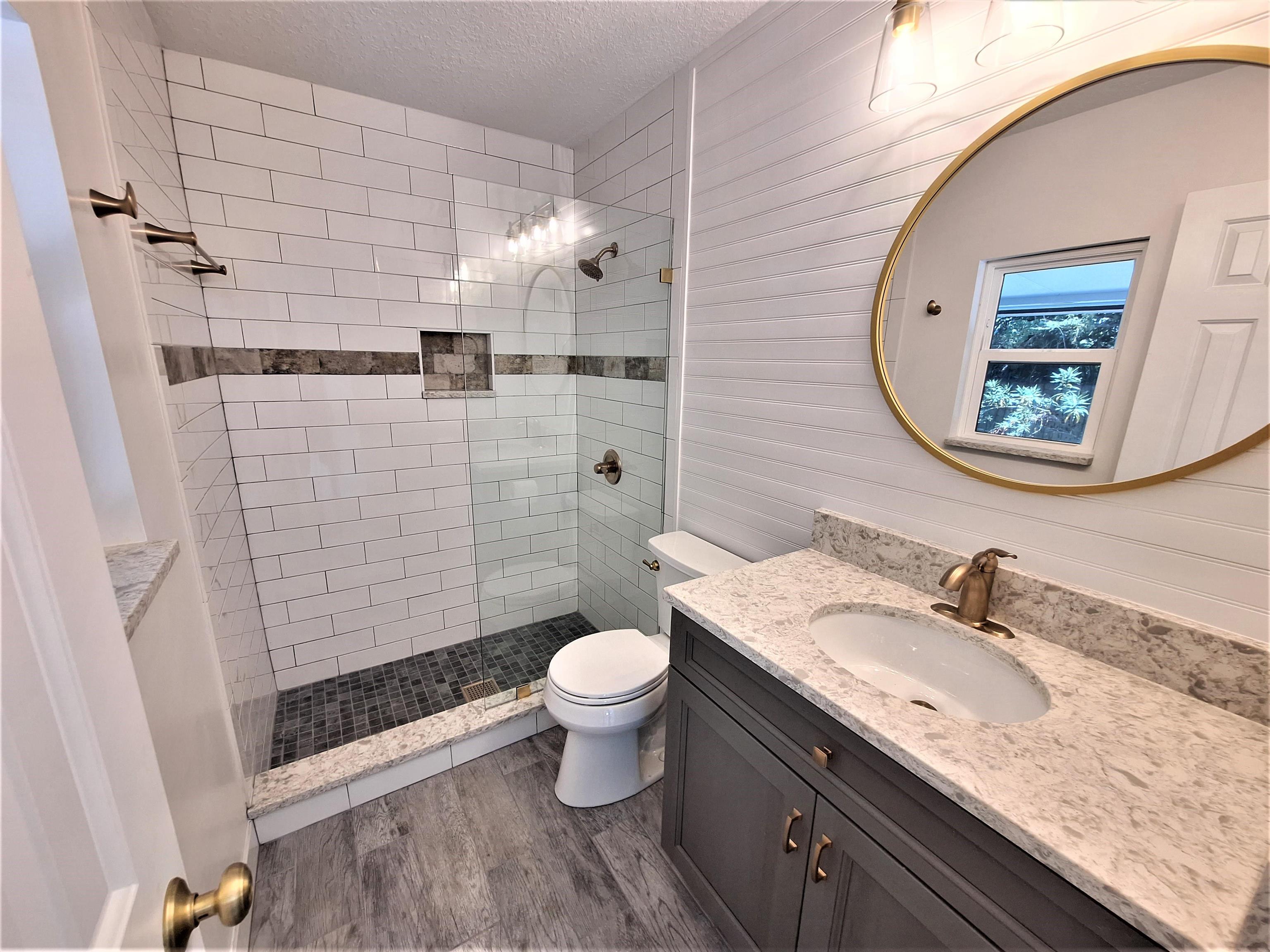 129 15th Street St. Augustine, FL 32080 - Photo 29 of 61 a bathroom with a granite countertop sink toilet and shower