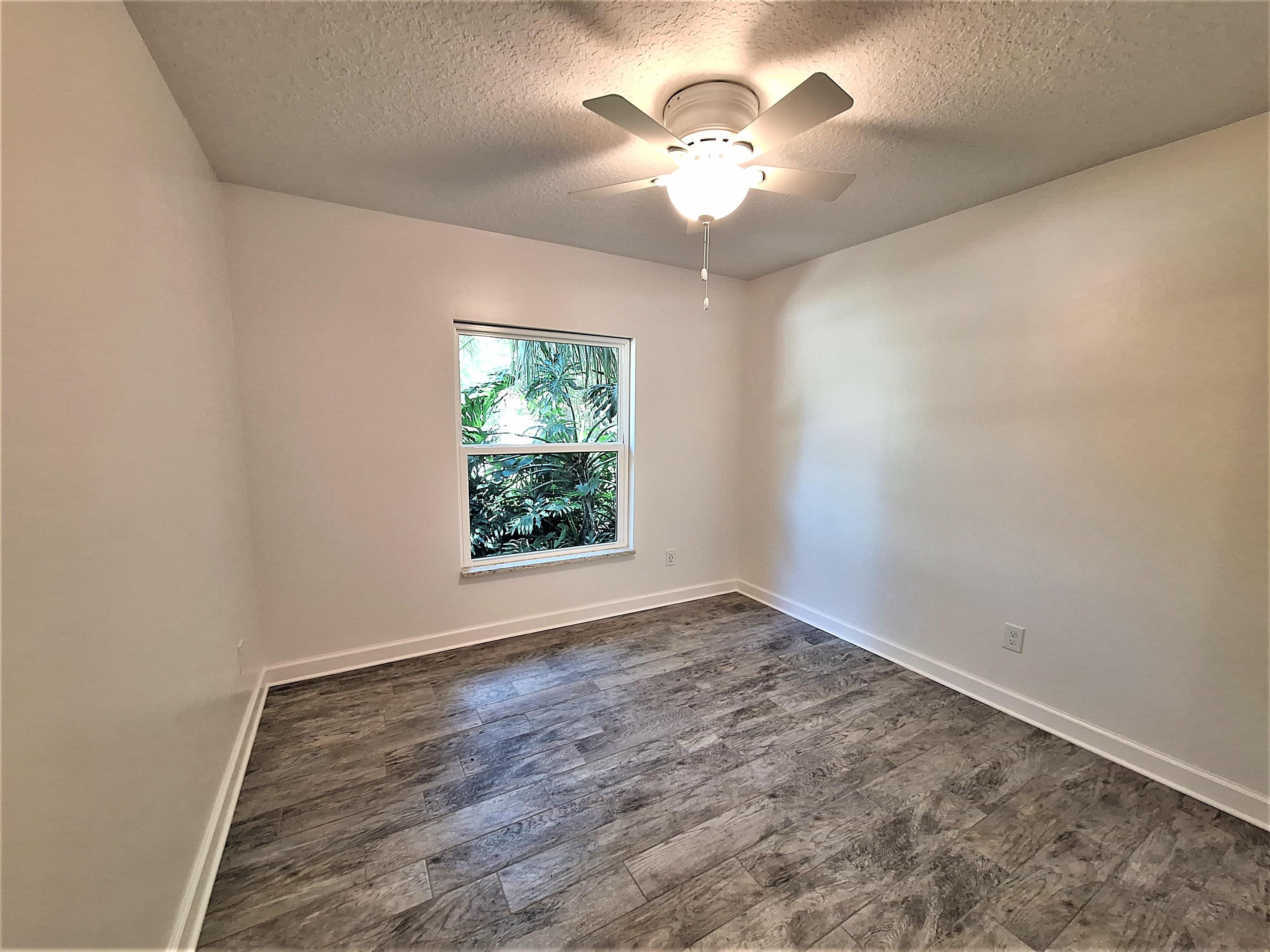 129 15th Street St. Augustine, FL 32080 - Photo 31 of 61 an empty room with wooden floor and a chandelier fan