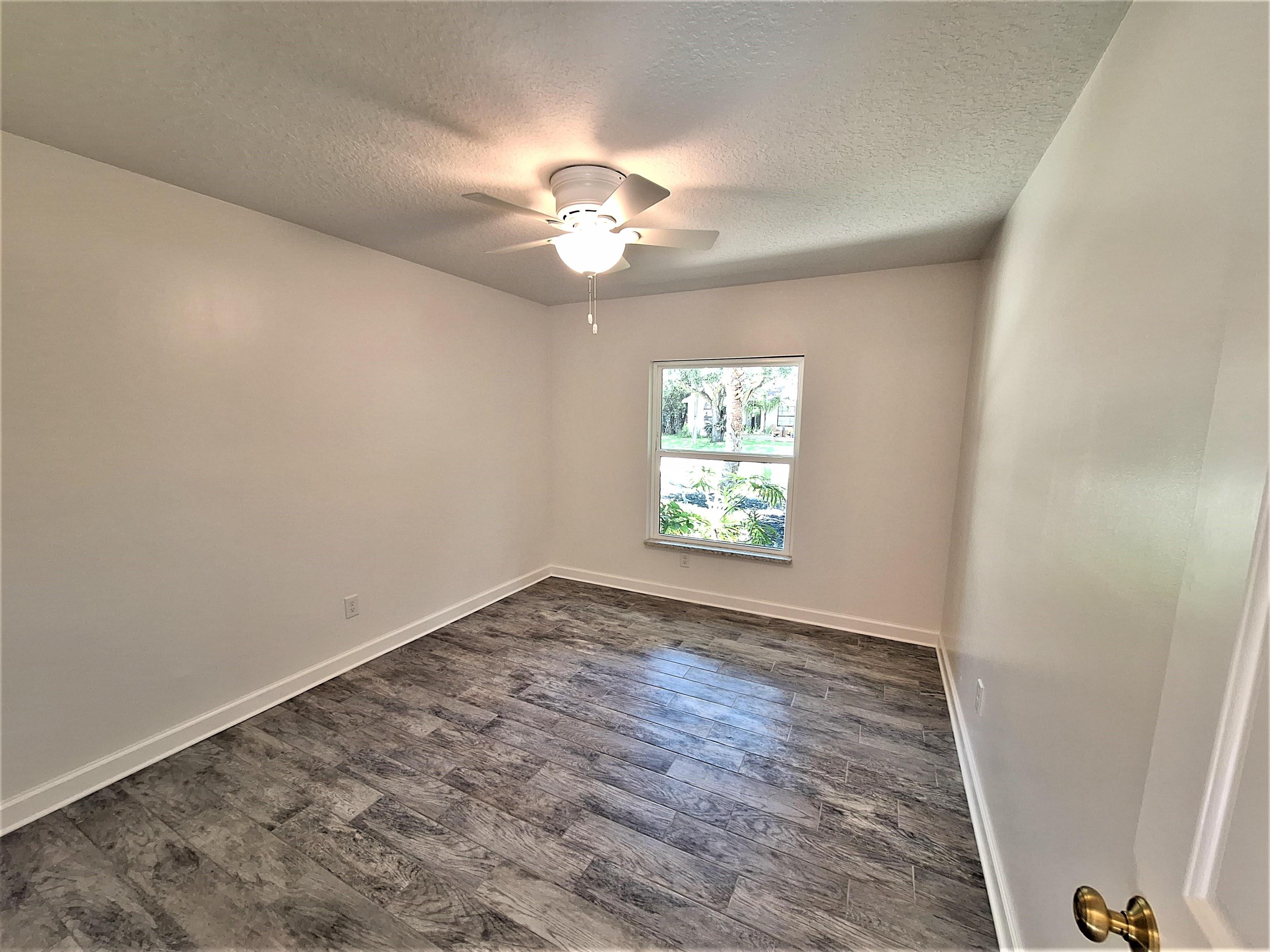 129 15th Street St. Augustine, FL 32080 - Photo 33 of 61 wooden floor in an empty room with a window