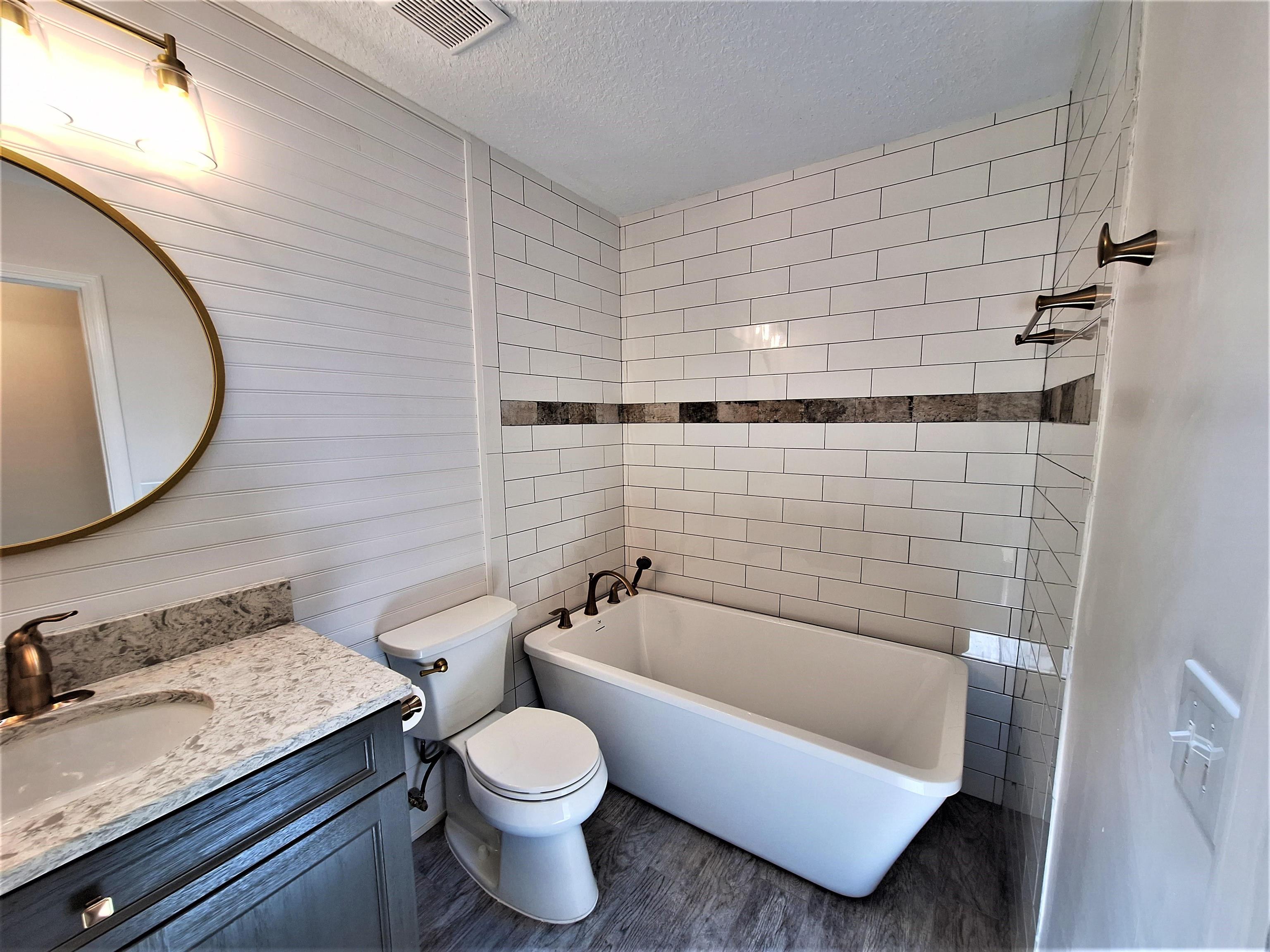 129 15th Street St. Augustine, FL 32080 - Photo 34 of 61 a bathroom with a granite countertop toilet sink and mirror