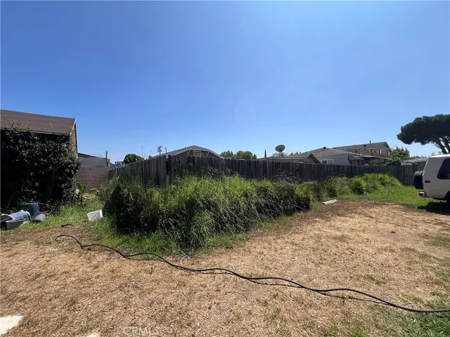 a view of a dry yard with trees