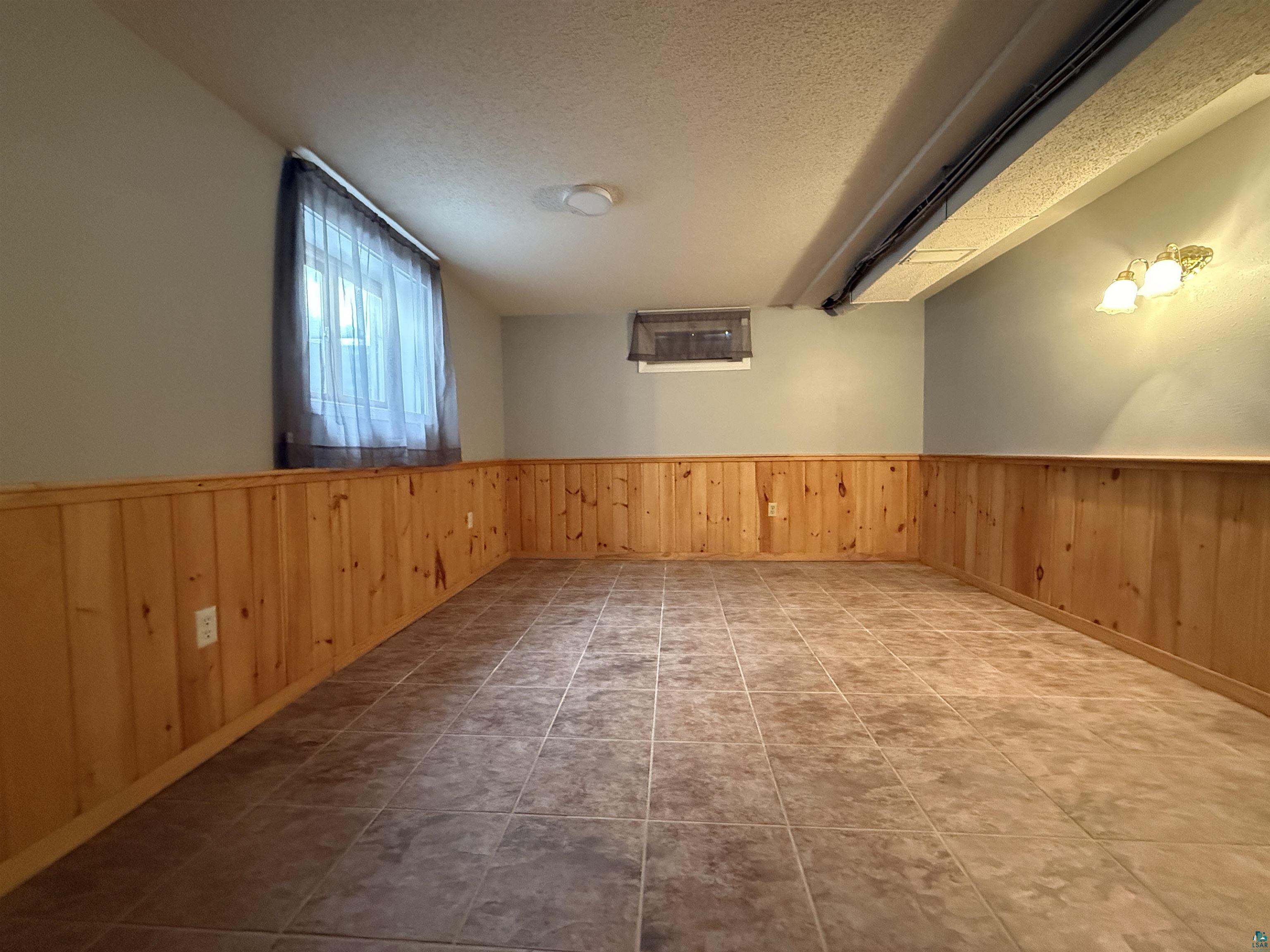 1321 South 13th Street Virginia, MN 55792 - Photo 23 of 33 Unfurnished room featuring a wainscoted wall, a textured ceiling, and wooden walls