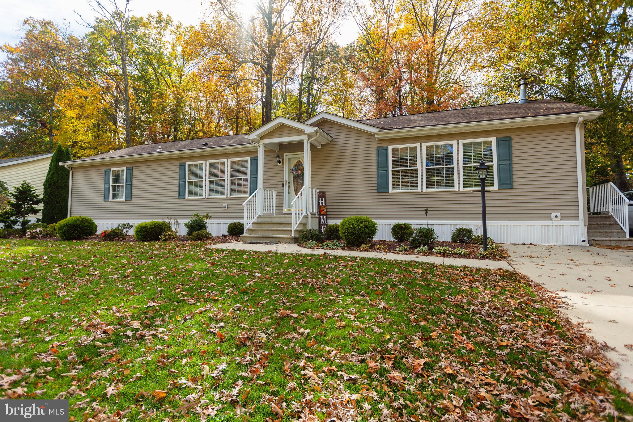 a front view of house with yard and trees around