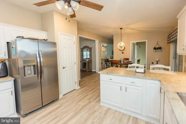 a spacious bathroom with a granite countertop sink mirror and refrigerator
