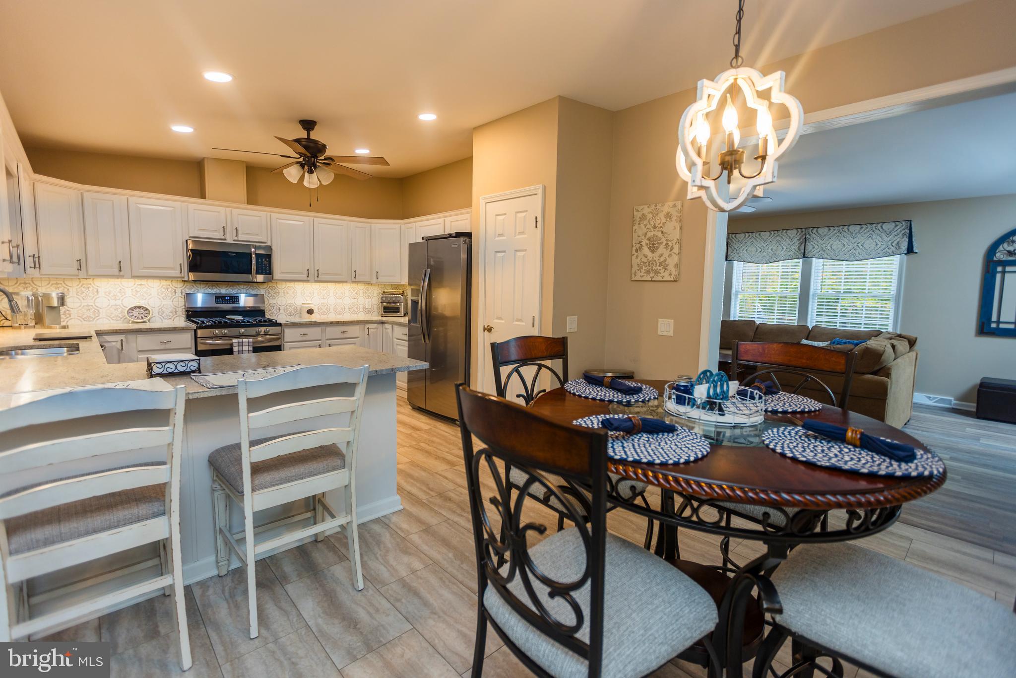 16 Cranberry Drive Cream Ridge, NJ 08514 - Photo 9 of 22 a kitchen with a dining table chairs refrigerator and cabinets