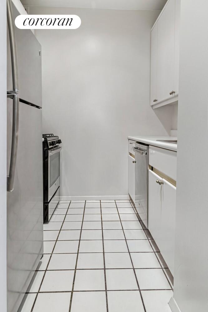 200 East 69th Street, Unit 4R Manhattan, NY 11360 - Photo 2 of 5 a kitchen with a stove cabinets and a refrigerator