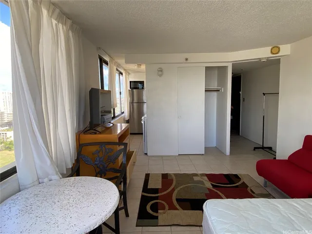 a living room with furniture a flat screen tv and a window