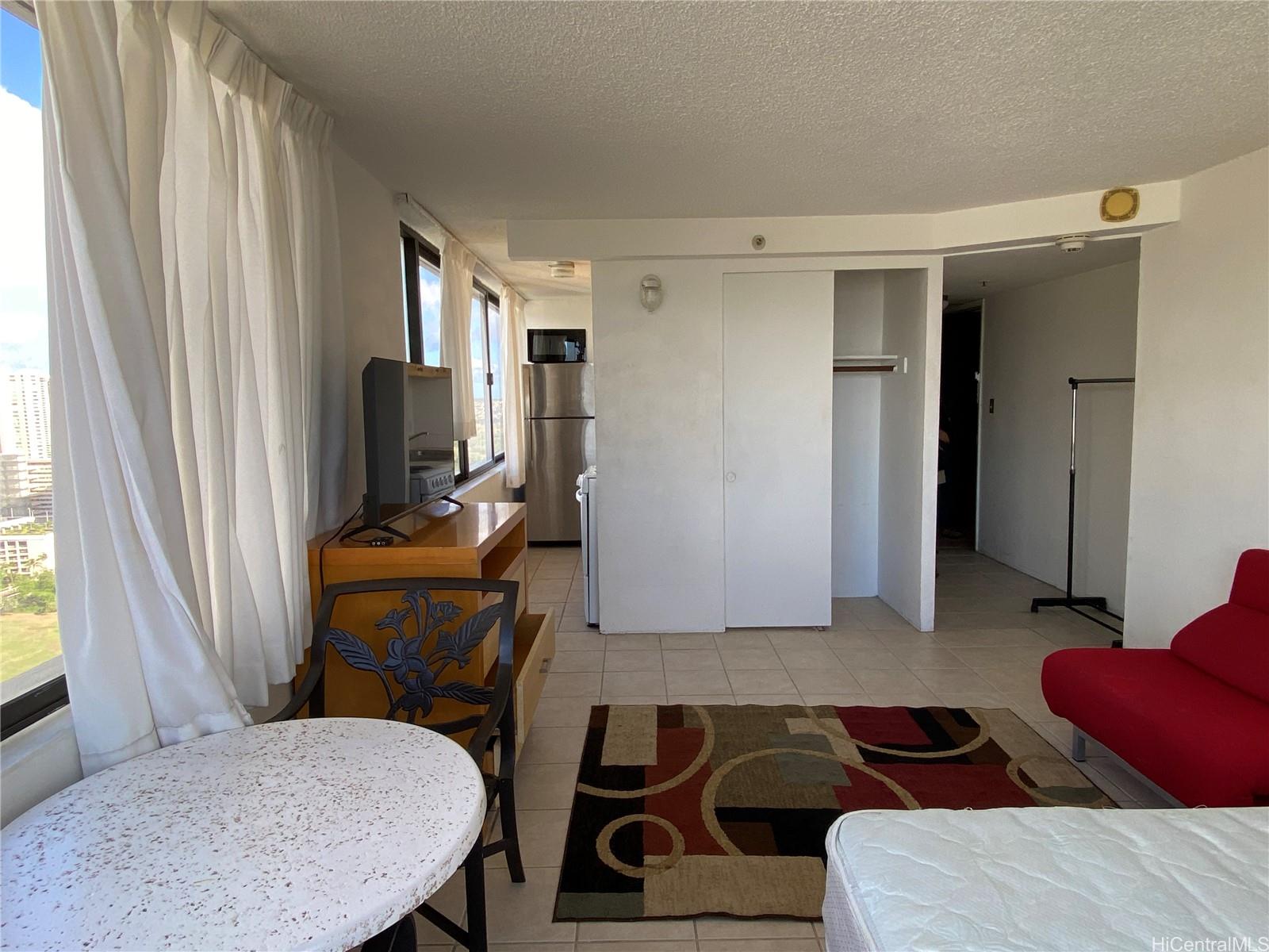 444 Niu Street, Unit 3407A Honolulu, HI 96815 - Photo 6 of 13 a living room with furniture a flat screen tv and a window