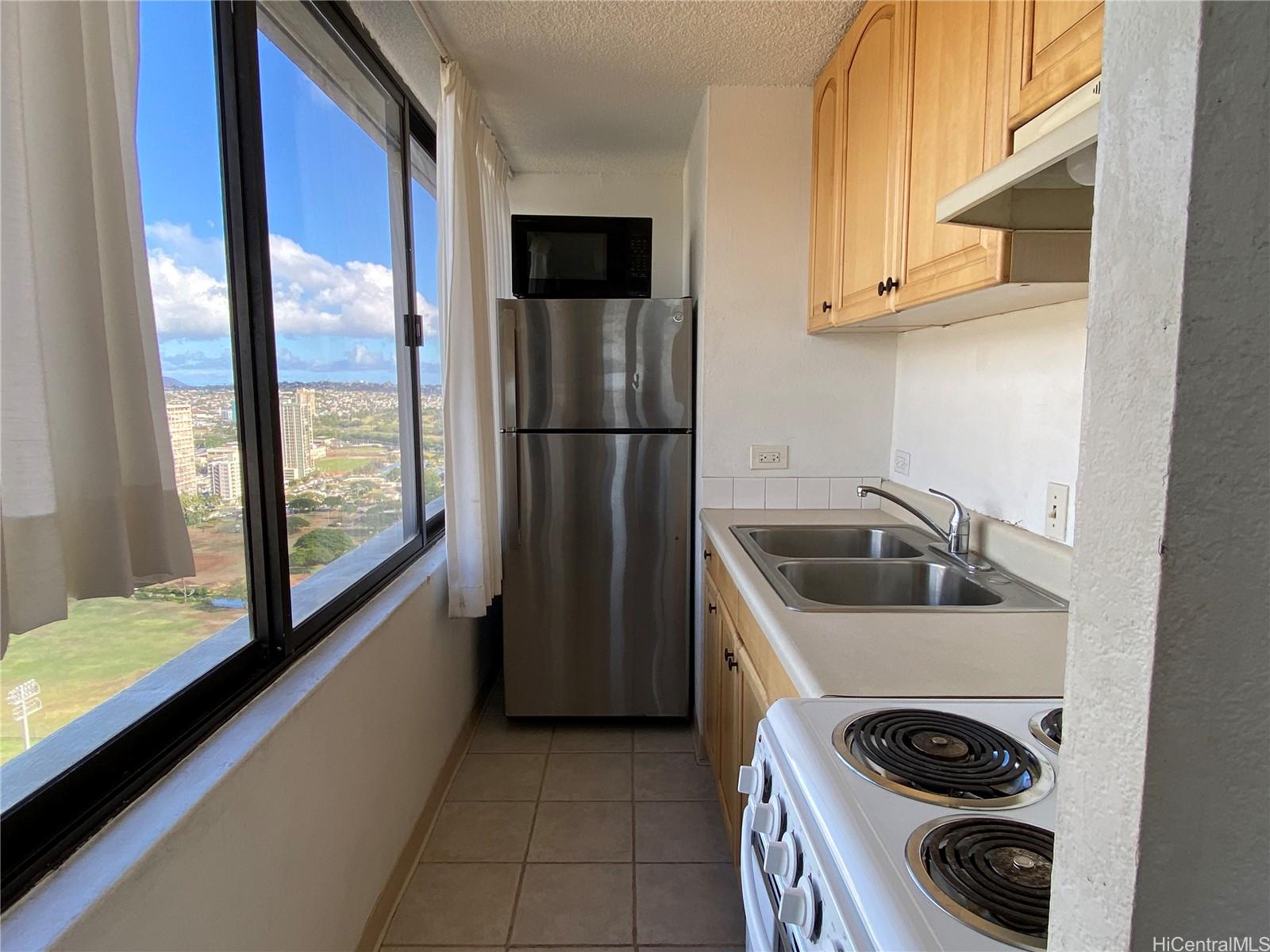444 Niu Street, Unit 3407A Honolulu, HI 96815 - Photo 7 of 13 a kitchen with a sink a refrigerator and a stove