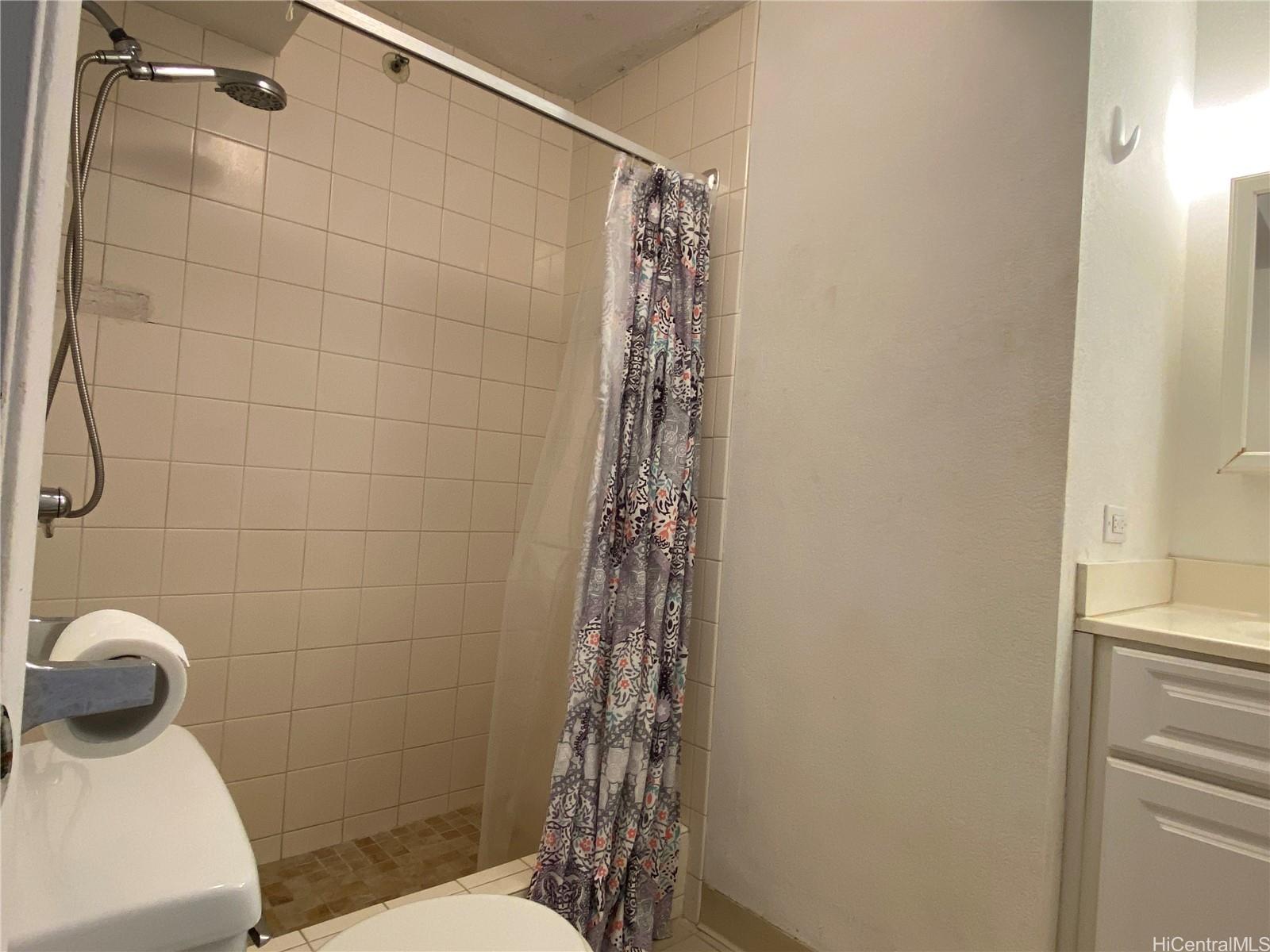 444 Niu Street, Unit 3407A Honolulu, HI 96815 - Photo 9 of 13 a bathroom with a shower a toilet and sink