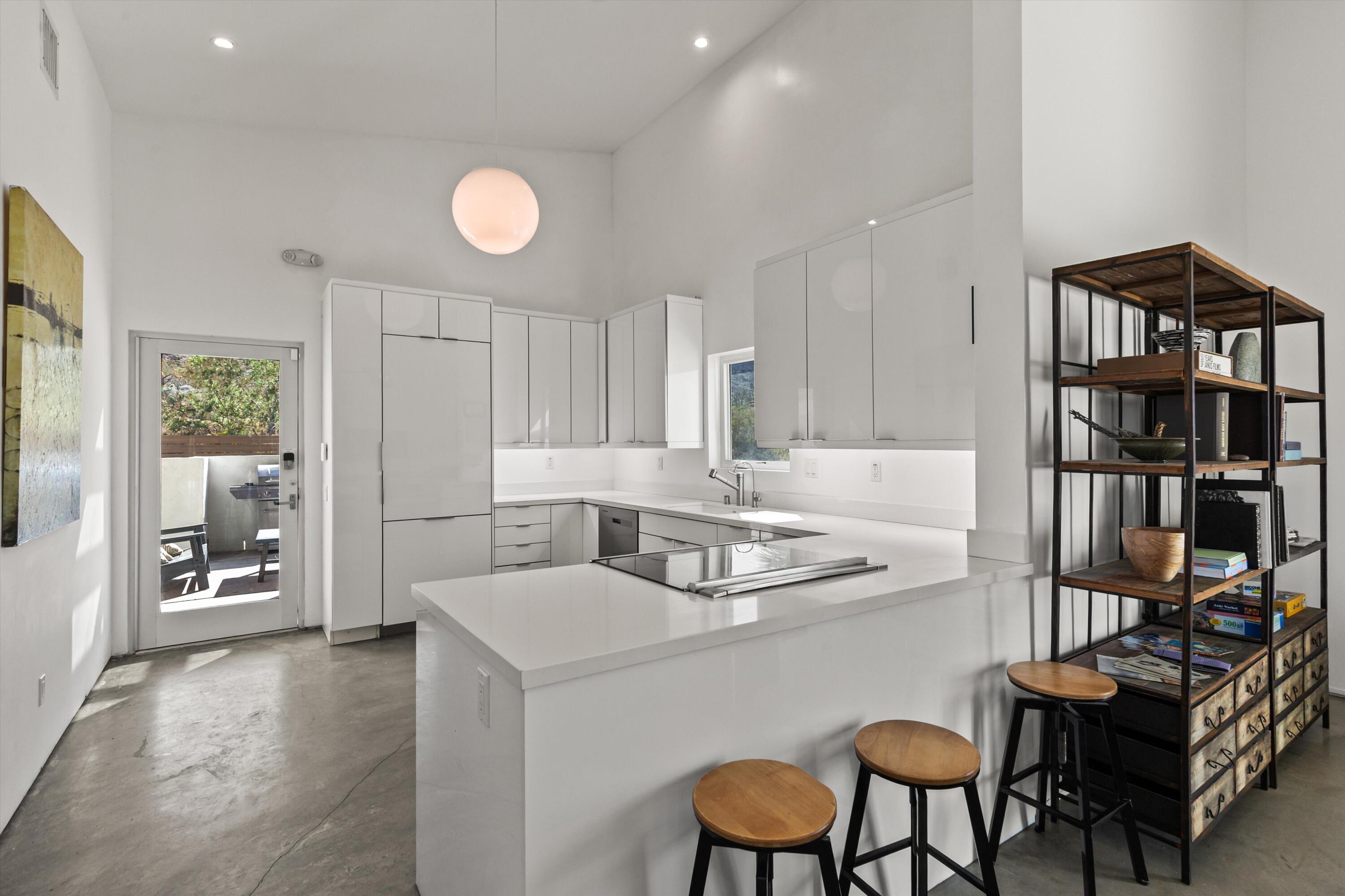 8825 Lilley Road Joshua Tree, CA 92252 - Photo 13 of 56 a kitchen with stainless steel appliances granite countertop a dining table chairs and a refrigerator
