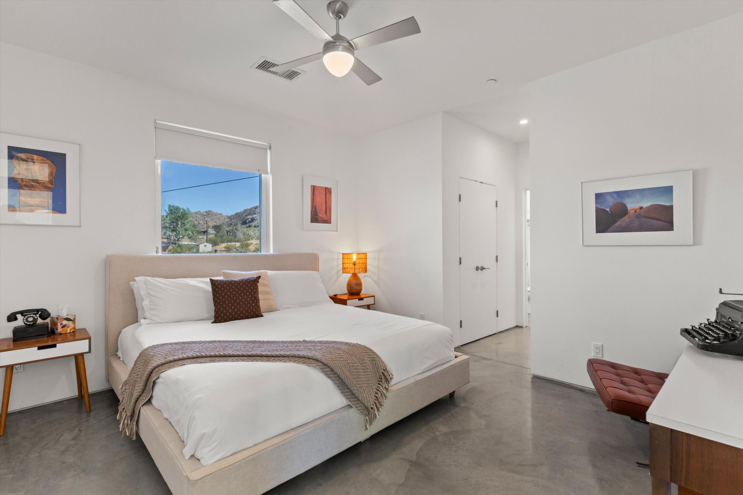 8825 Lilley Road Joshua Tree, CA 92252 - Photo 29 of 56 a bedroom with a bed and a chandelier