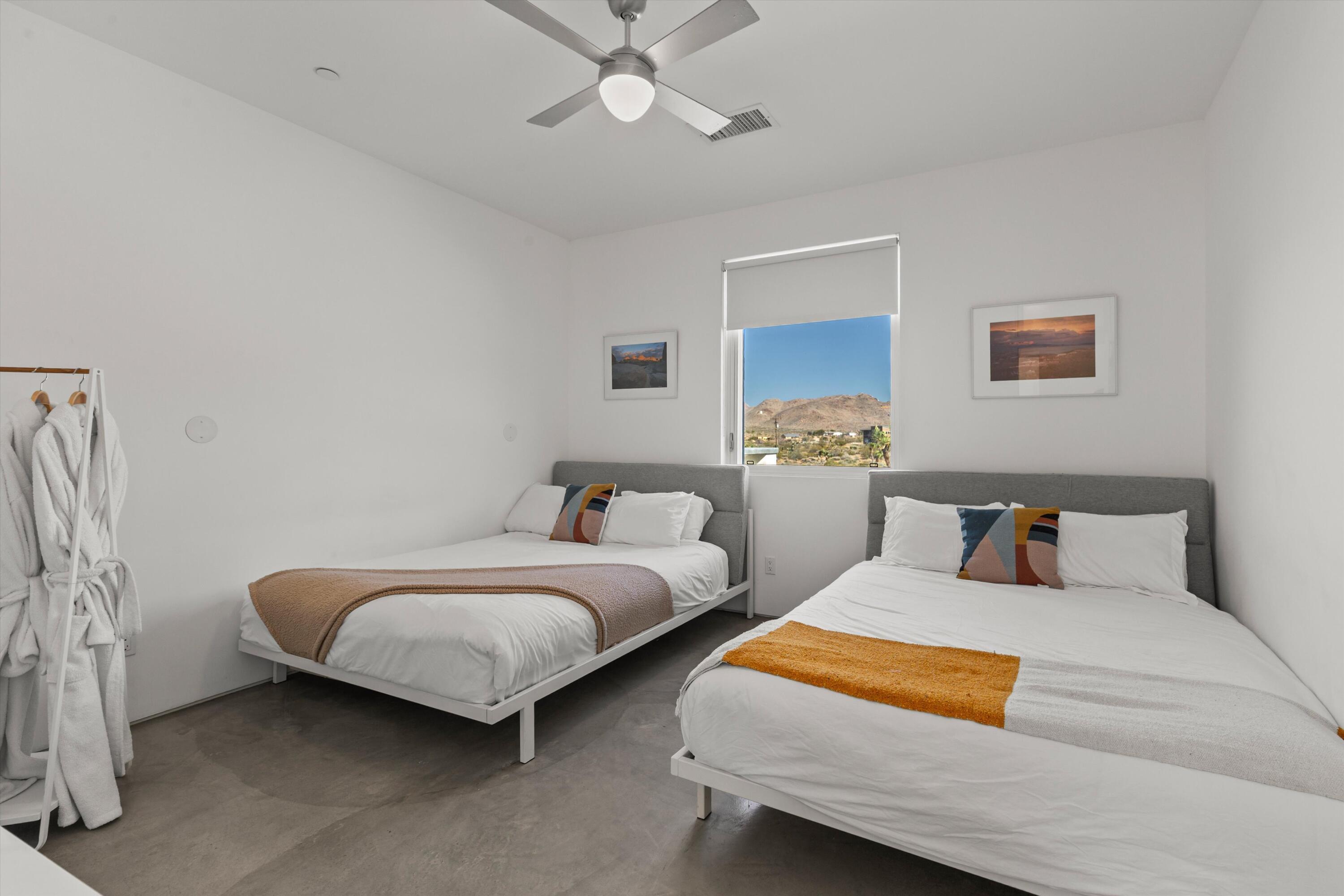 8825 Lilley Road Joshua Tree, CA 92252 - Photo 39 of 56 a bedroom with two beds and painting on the wall