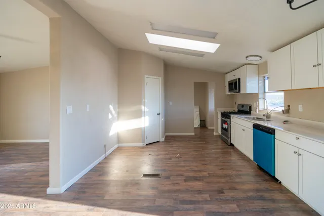 a large kitchen with cabinets and wooden floor