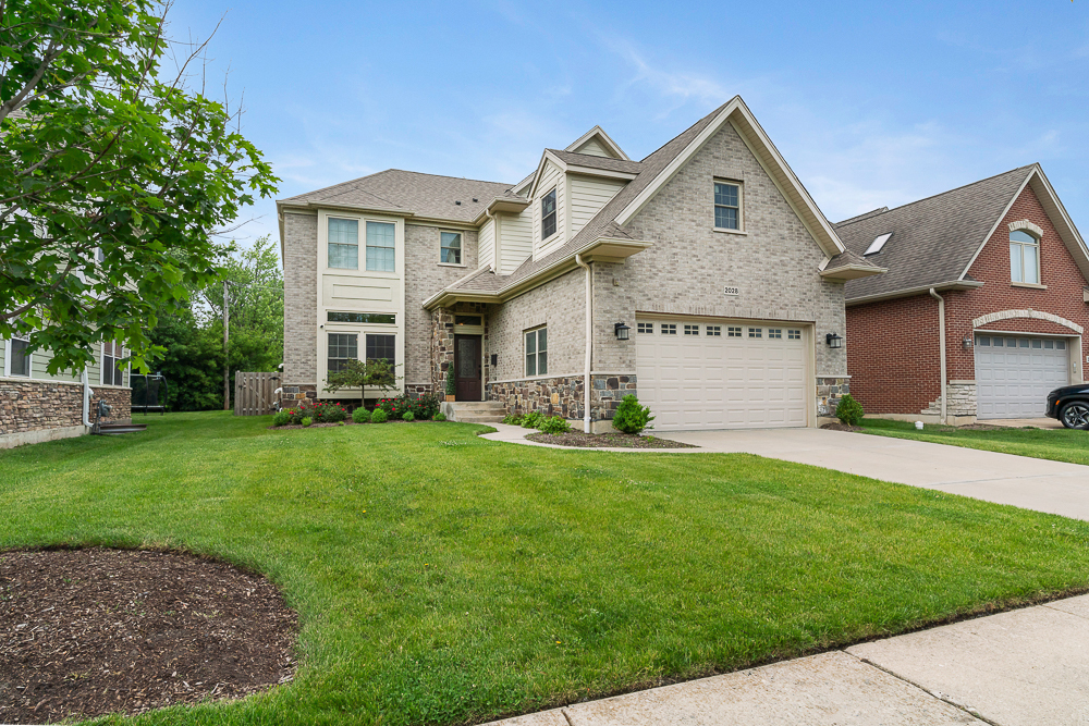 a front view of a house with a garden and yard